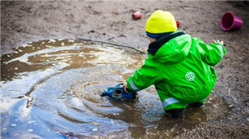 kid playing in a puddle