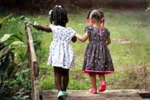 two girls walking on brown bridge during daytime