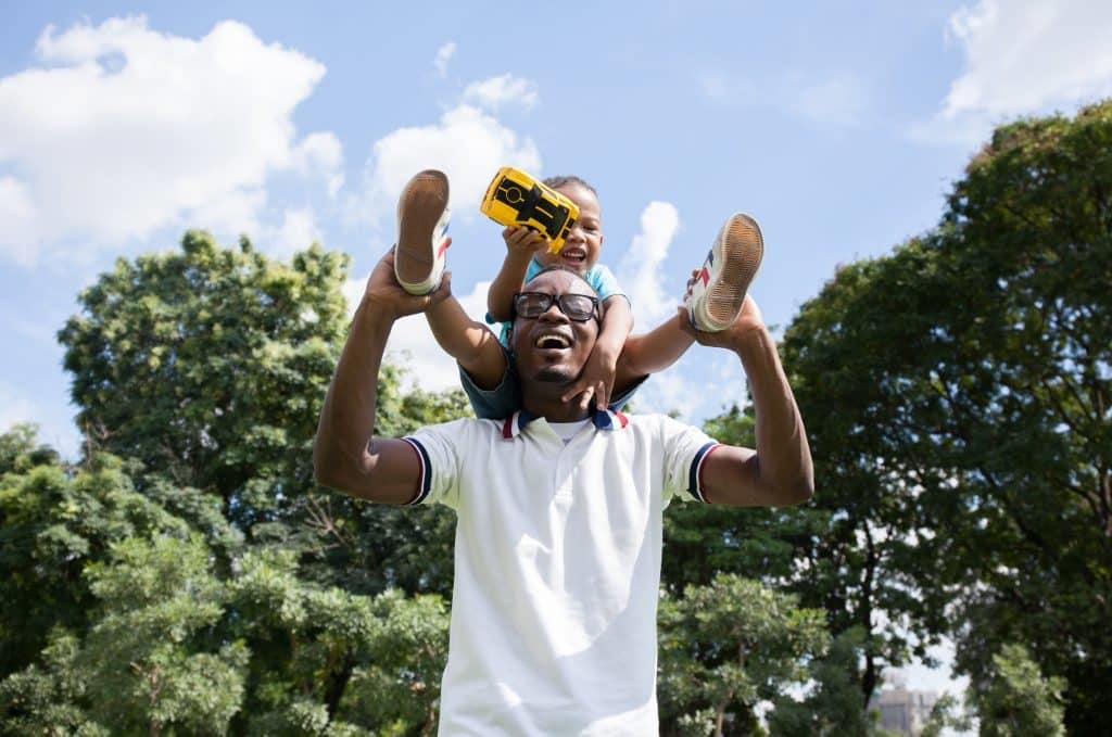 image of a black father/carer and a young black boy on his shoulders