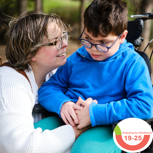 image a of young boy in a wheelchair with a parent or carer